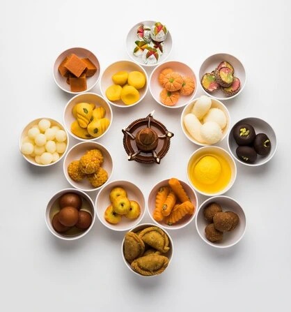 rangoli-assorted-indian-sweets-mithai-bowl-diwali-any-other-festivals-selective-focus_466689-44244.jpg
