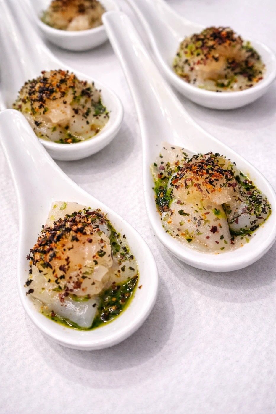 Petite cuillère de carpaccio de Saint-Jacques, algues marines, piment d’Espelette et huile confite aux herbes.jpg