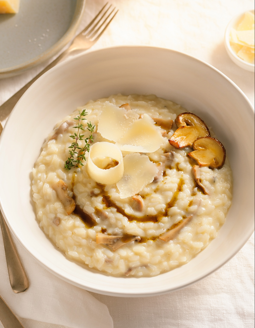 Firefly_Creamy porcini mushroom risotto in a wide white bowl, aged parmesan shavings, truffle 196134.png