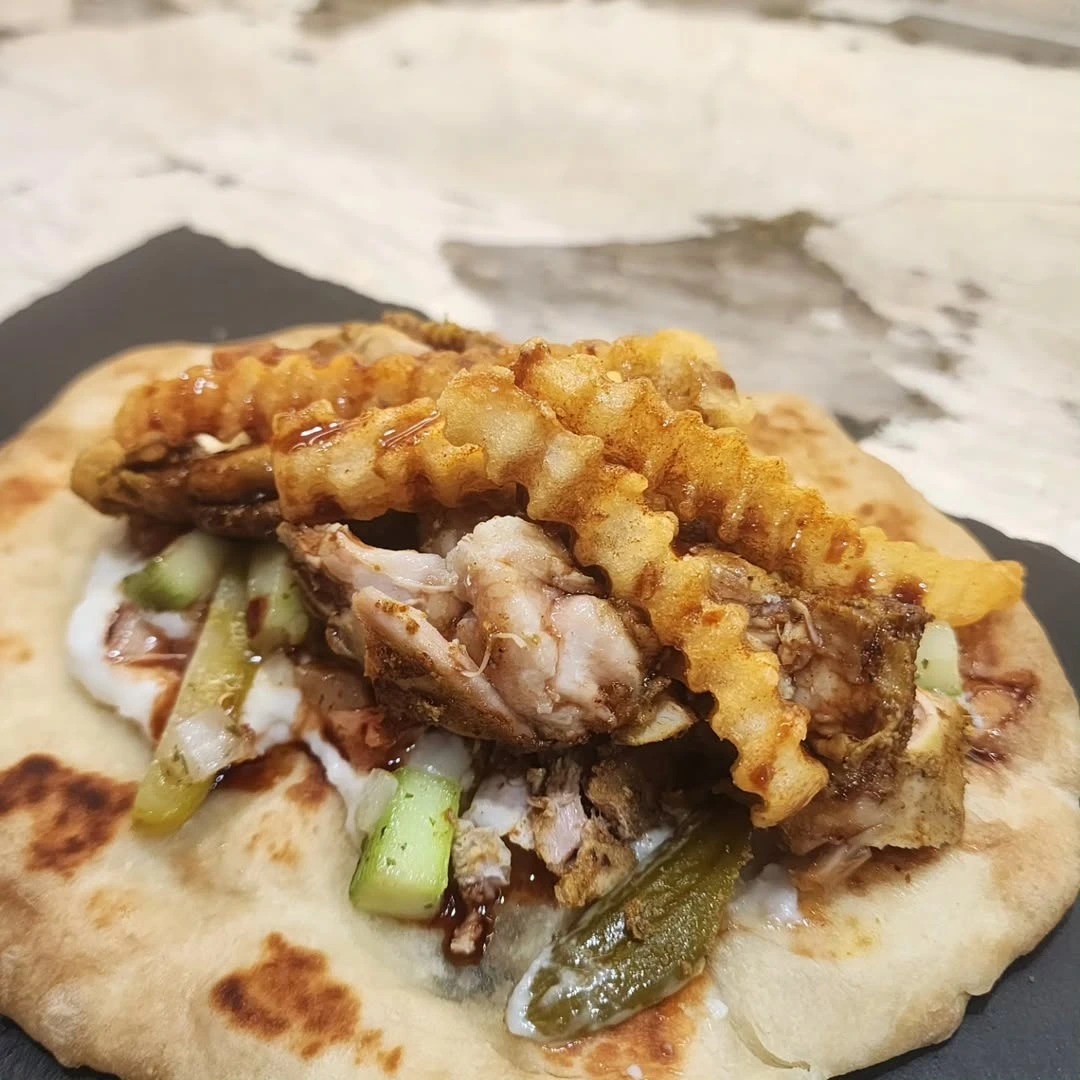 Home-made chicken schawarma served on a fresh made pita, garlic sauce, arabic salad, pickles, crispy fries, and pomegranate molasses drizzled on top. yessssir (14).png Home-made chicken schawarma served on a fresh made pita, garlic sauce, arabic salad, pickles, crispy fries, and pomegranate molasses drizzled on top. yessssir (14).png