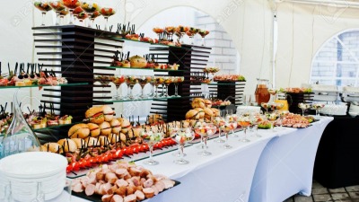 Mesa de buffet de recepción con hamburguesas bocadillos calientes carnes y ensaladas