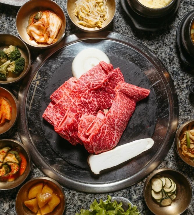 Waygu beef strips ready to be basted in bbq sauce surrounded by grilled vegetables
