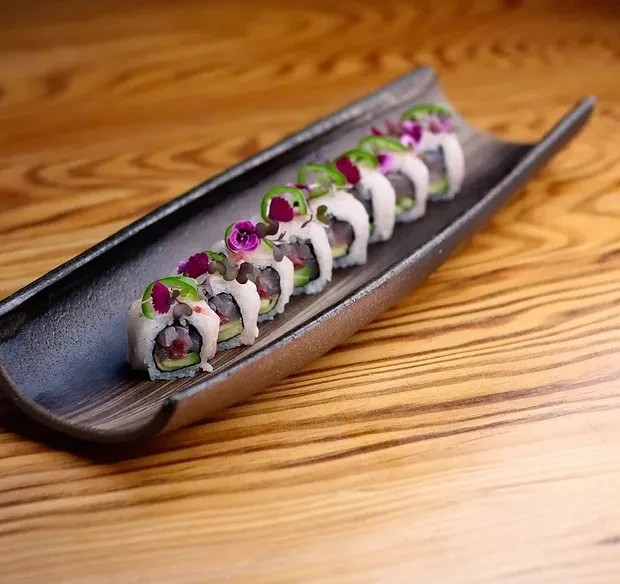 Salmon nigiri being picked up with chopsticks