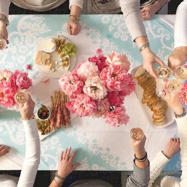 Aerial shot of a beautiful dining table decorated with pink flowers and a clear blue tablecloth