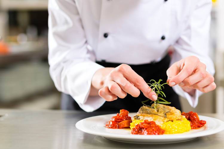 A private chef in Ottawa finishing the cooking of a dish A private chef in Ottawa cooking a dish