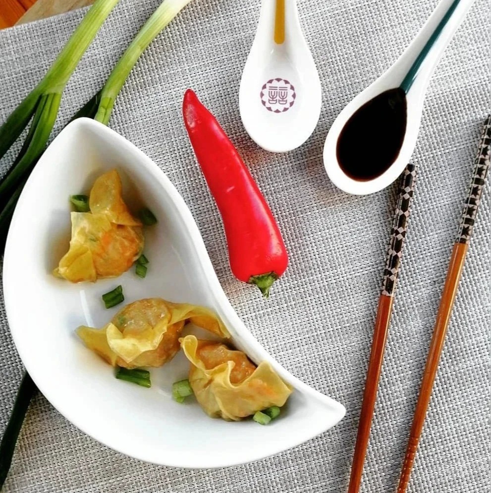 A smiling chef prepares ingredients on the kitchen counter on a white and well lit kitchen