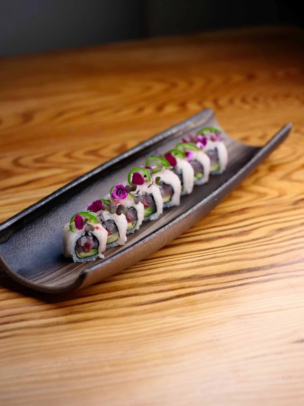 Salmon nigiri being picked up with chopsticks